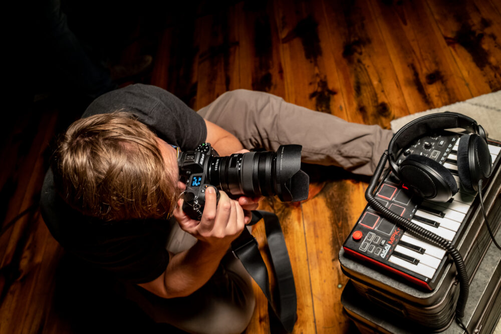Ein Fotograf fotografiert einen Kopfhöhrer der auf einem Midi-Keyboard liegt.