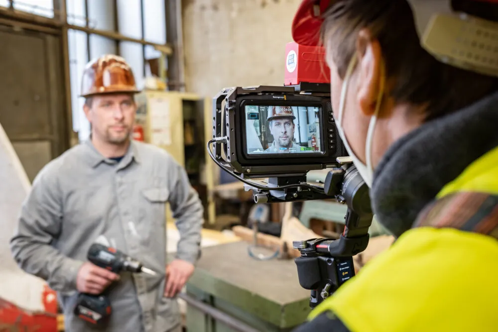 Kameramann im Vordergrund filmt einen Handwerker für einen Livestream