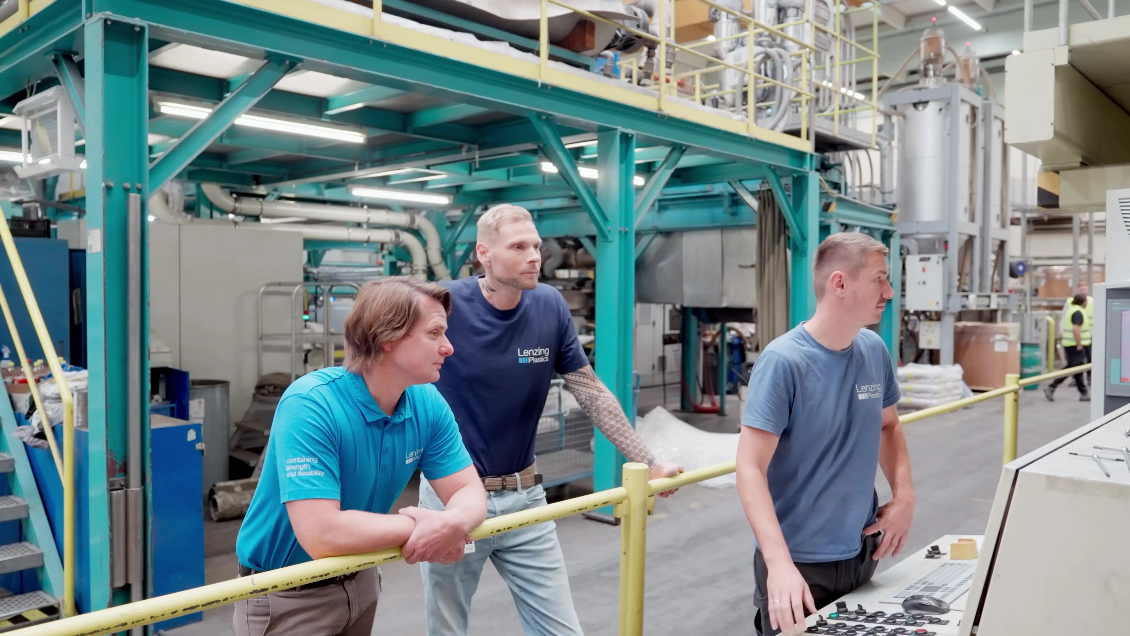 Eine Gruppe von Farbikmitarbeitern bei einer Pause vor einer großen Maschine