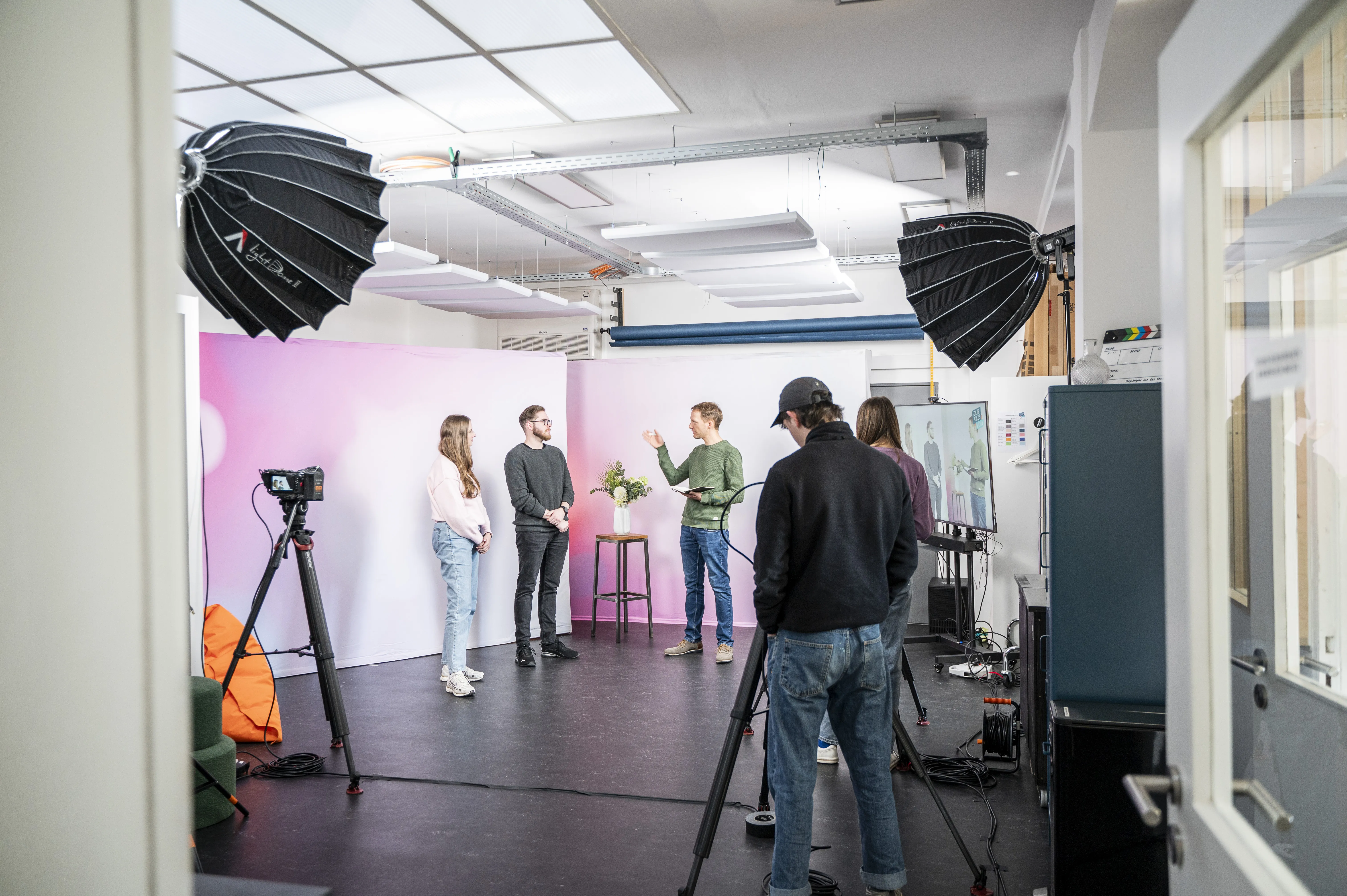 Eine Gruppe von Menschen in einem ausgeleuchteten Studio von Fokuspokus Media
