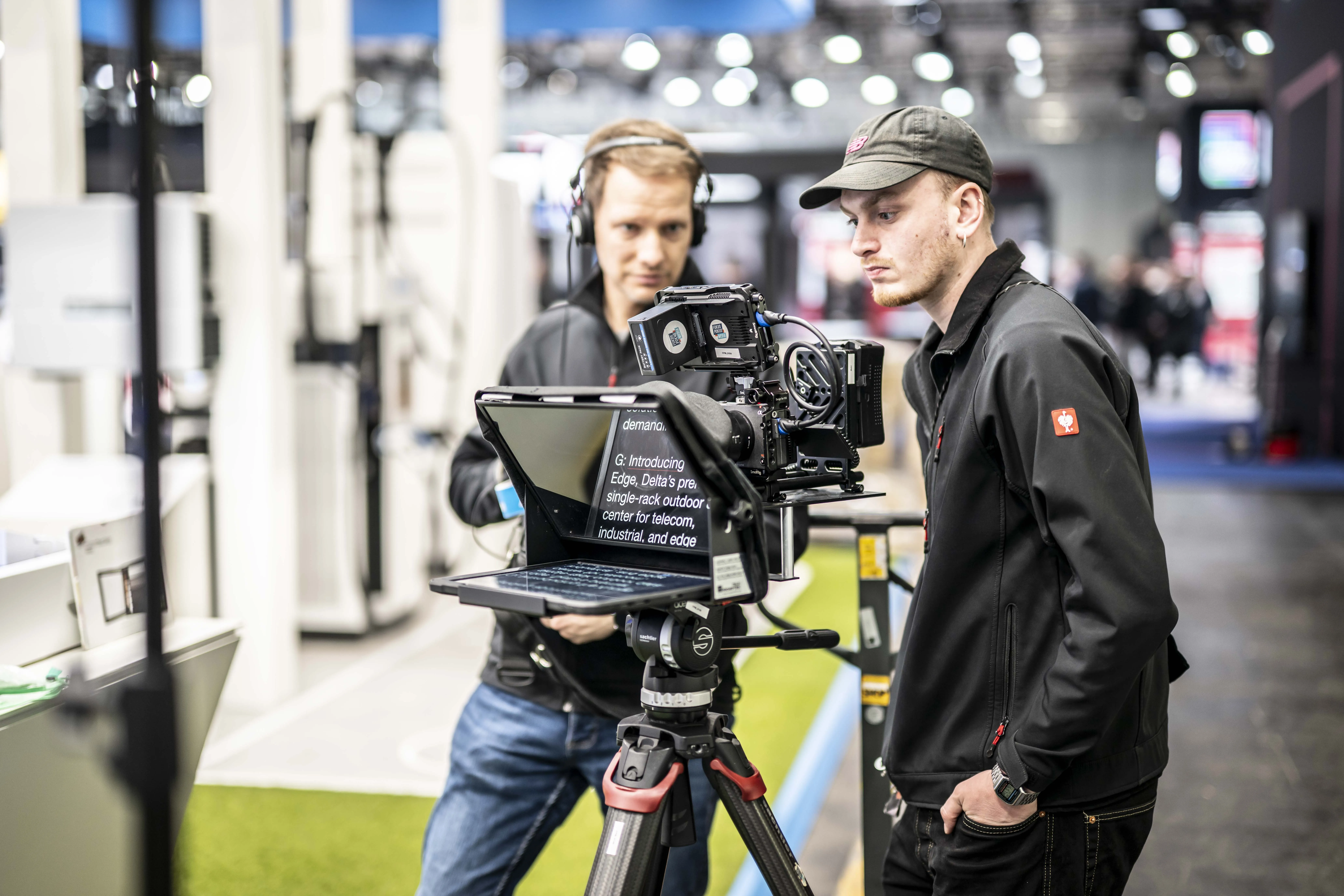 Ein Regisseur und ein Kameramann mit einem Teleprompter auf einer Messe in Hannover