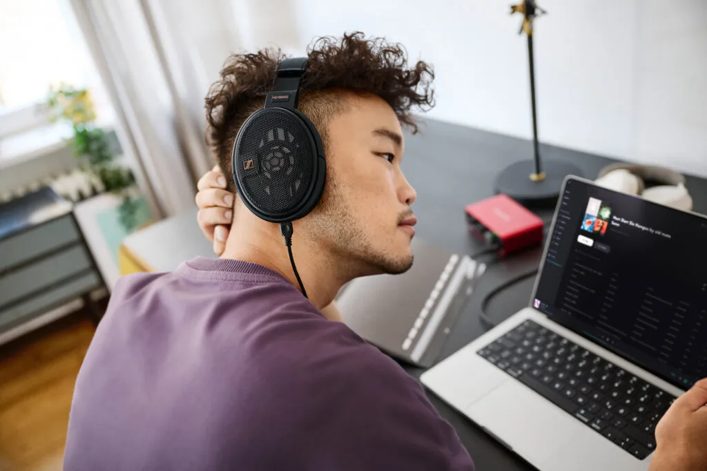 Mann hört am Laptop mit Sennheiser HD 660S2 Kopfhörer Musik