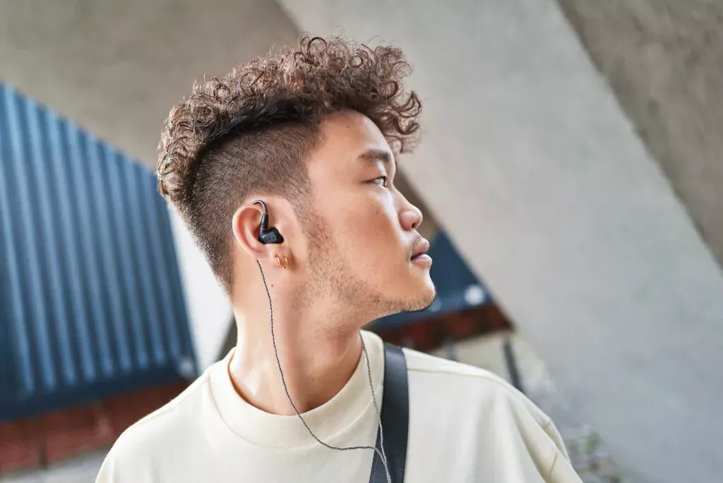 Seitliches Porträt mit schwarzem Sennheiser IE 200 In-Ear-Kopfhörer