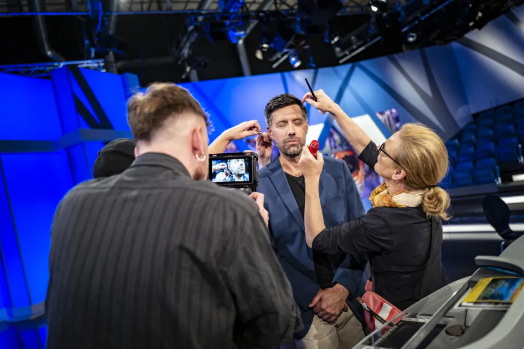 Im Studio wird ein Protagonist abgepudert