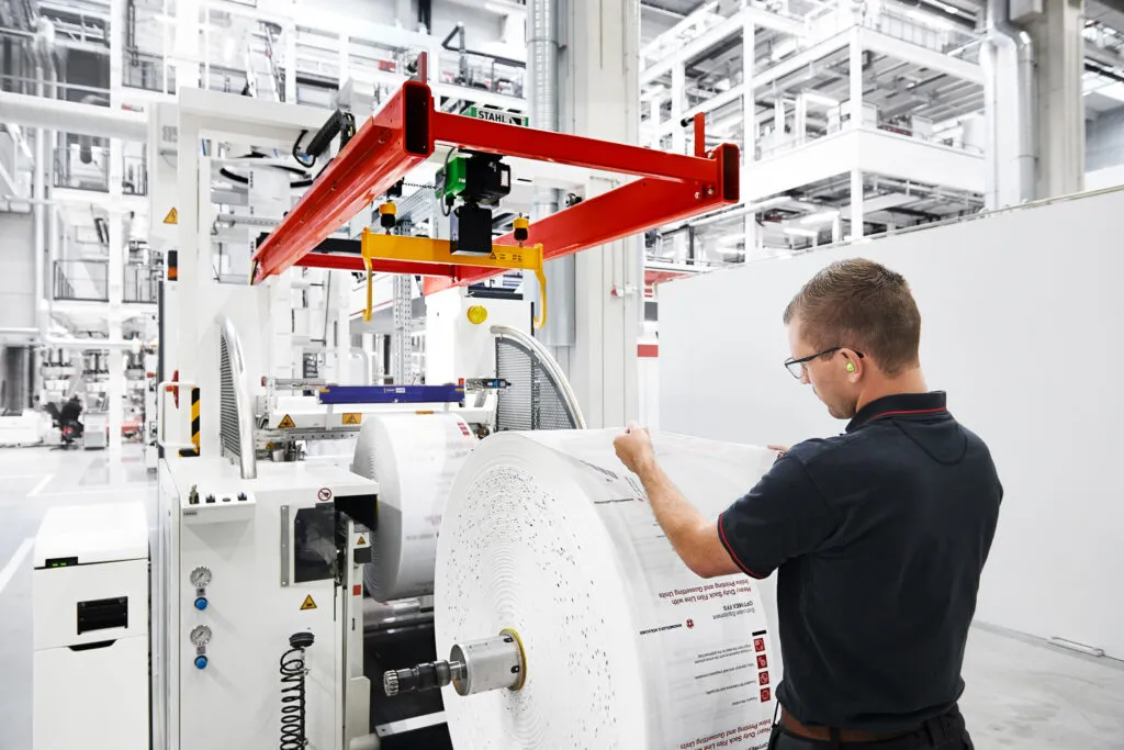 Industrieaufnahme einer Produktionsmaschine von Windmöller & Hölscher mit großer Materialrolle