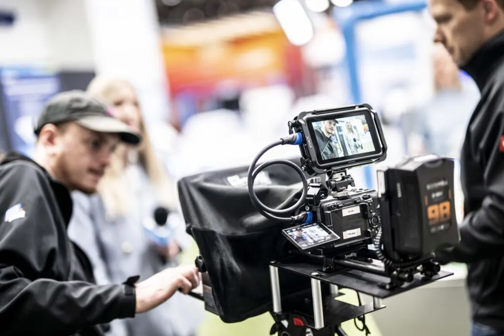 eine Kamera scharf im vordergrund auf einem Messestand auf der Hannover Messe