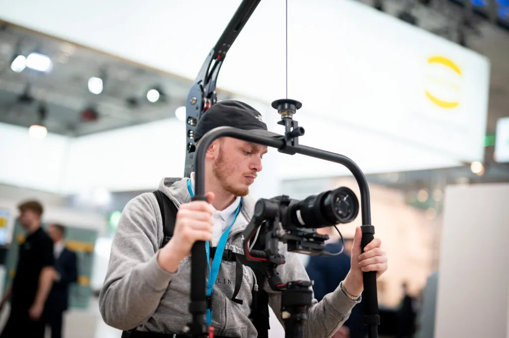 Ein Kameramann von Fokuspokus Media filmt einen Messestand auf der Hannover Messe