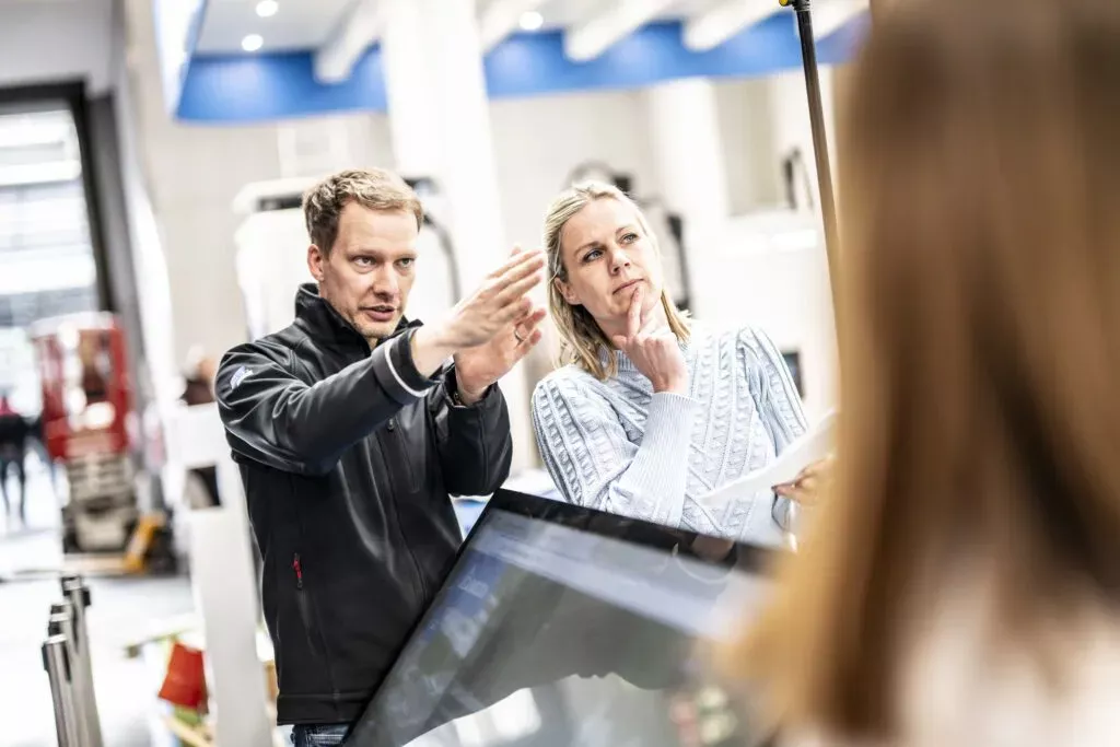 Ein Projektmanager bespricht auf einer Messe den Bildausschnitt mit dem Kunden