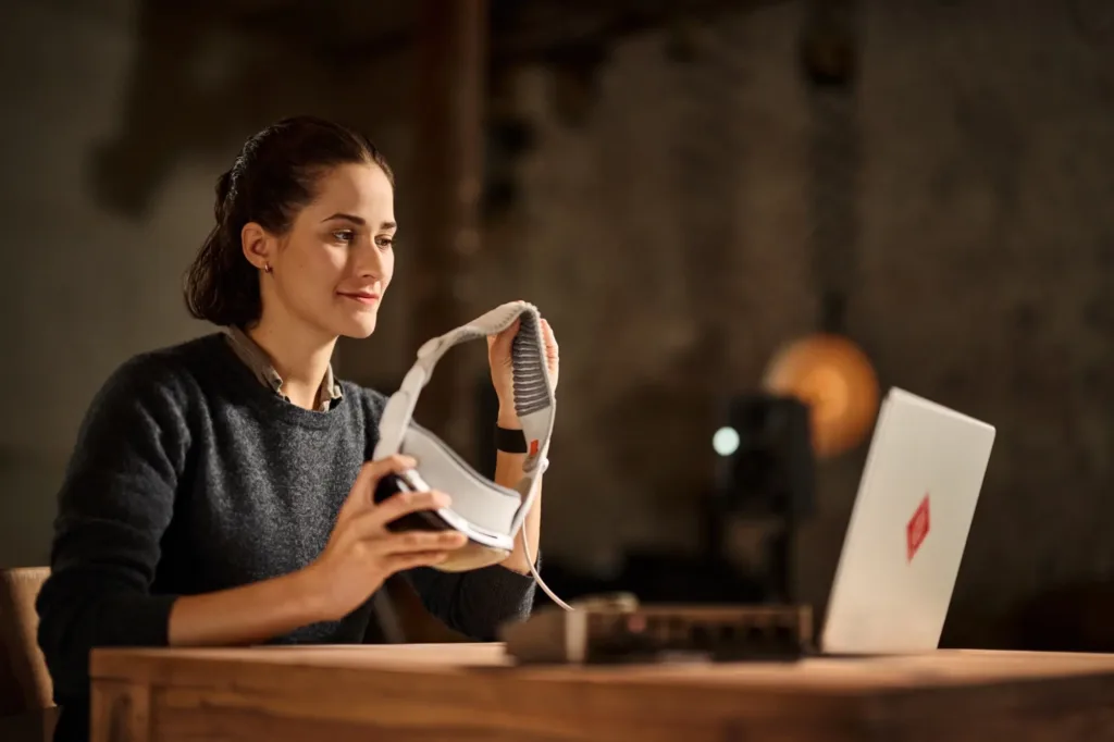 Anwenderin nimmt die Apple Vision Pro für die Arbeit mit Neumann VIS in die Hand