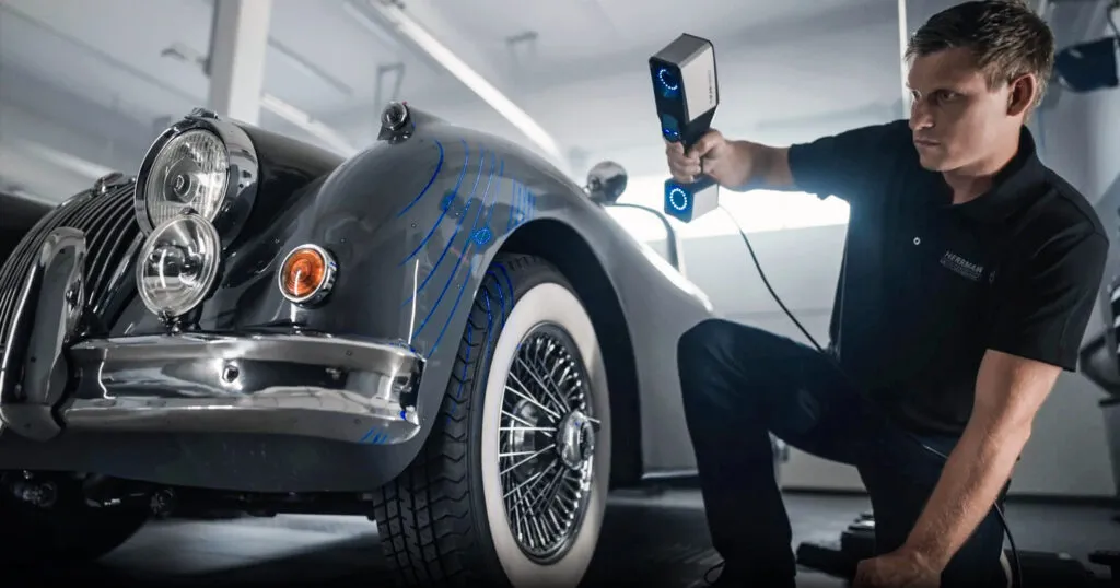 Ein Mann scannt ein Auto mit einem Handscanner von ZEISS