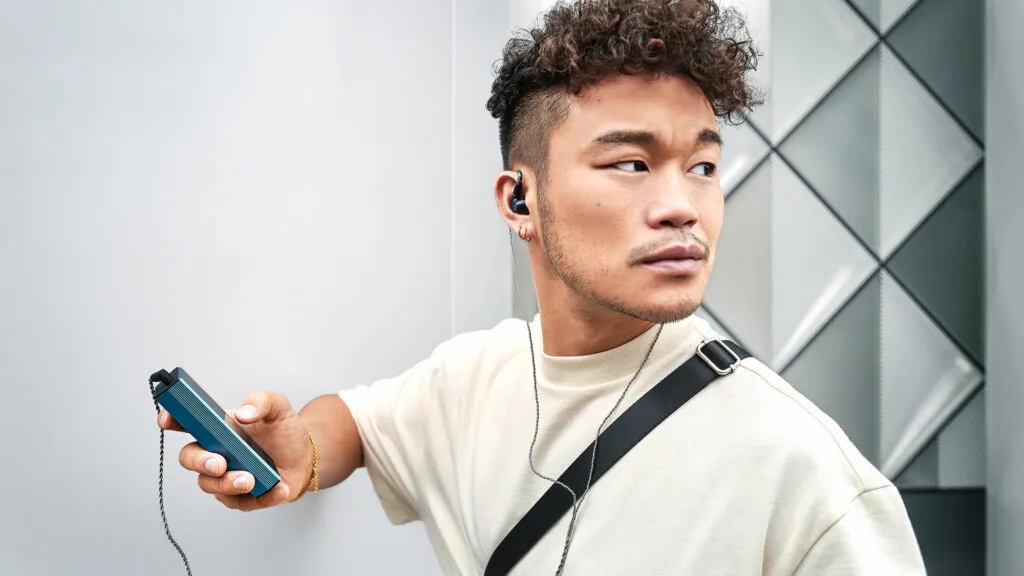 Nahaufnahme eines Mannes mit Sennheiser IE 200 und mobilem Abspielgerät
