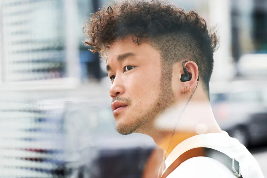 Porträt eines Mannes mit Sennheiser IE 200 In-Ear-Kopfhörer in Berlin