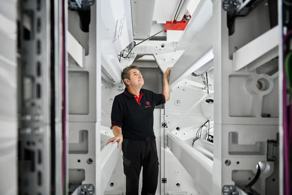 Mitarbeiter von Windmöller & Hölscher kontrolliert eine industrielle Produktionsmaschine