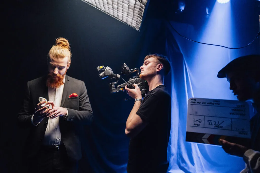 Ein Kameramann filmt einen Zauberer mit Spielkarten in der Hand auf einem Filmset für einen Imagefilm in Hannover