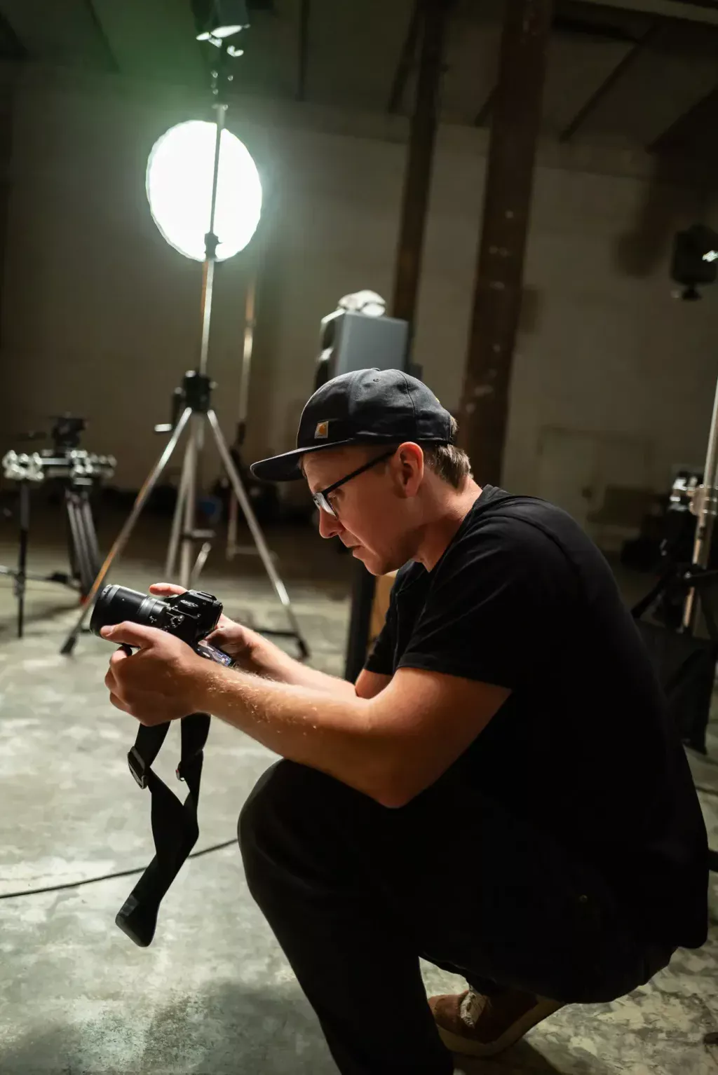 Fotograf kontrolliert eine Aufnahme während der kombinierten Film- und Fotoproduktion