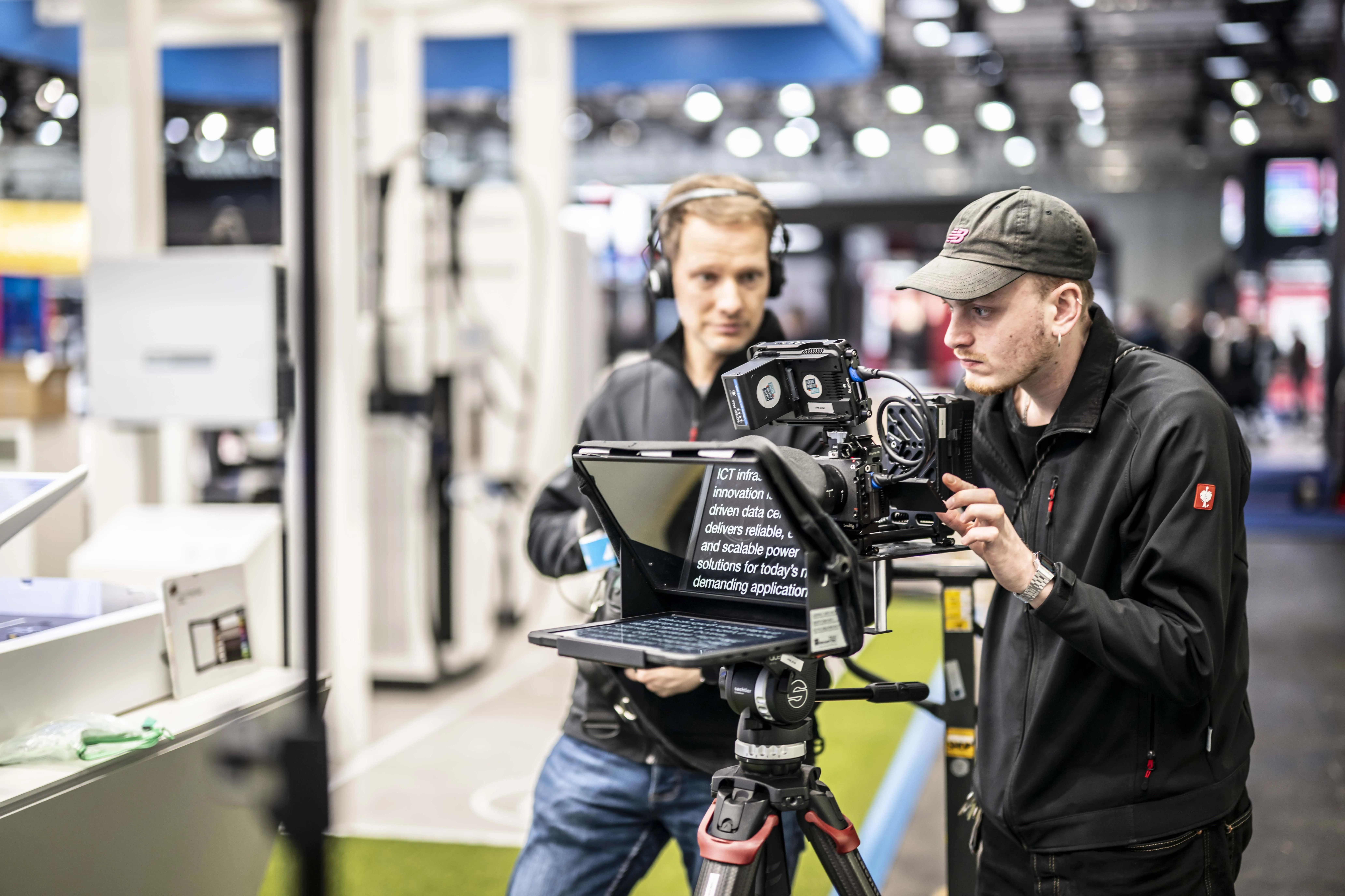 Filmcrew mit Teleprompter auf einem Messestand von Delta